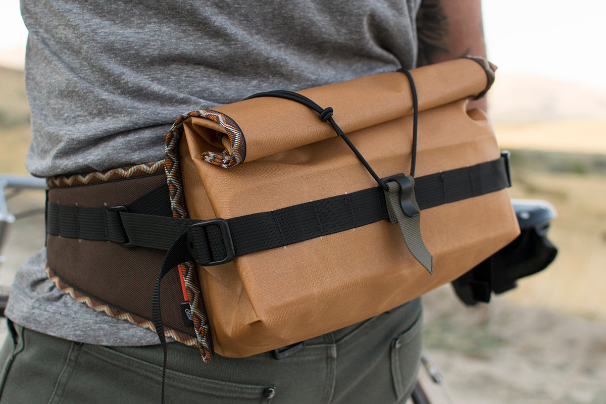 Person wearing an orange Big Dumpling hip pack with Western Rattler trim tape.
