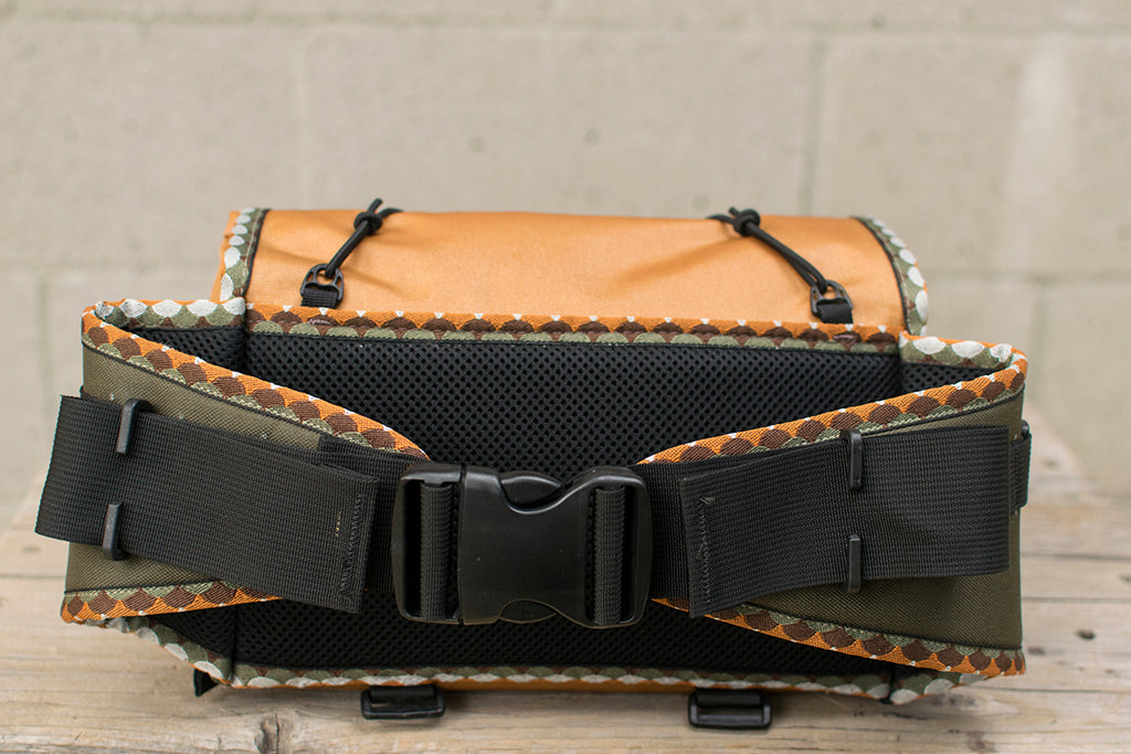 A back view of the orange Big Dumpling hip pack with Brown Trout patterned trim tape.