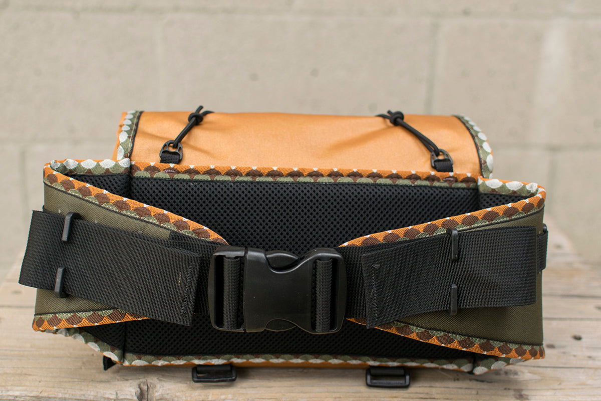 A back view of the orange Big Dumpling hip pack with Brown Trout patterned trim tape.