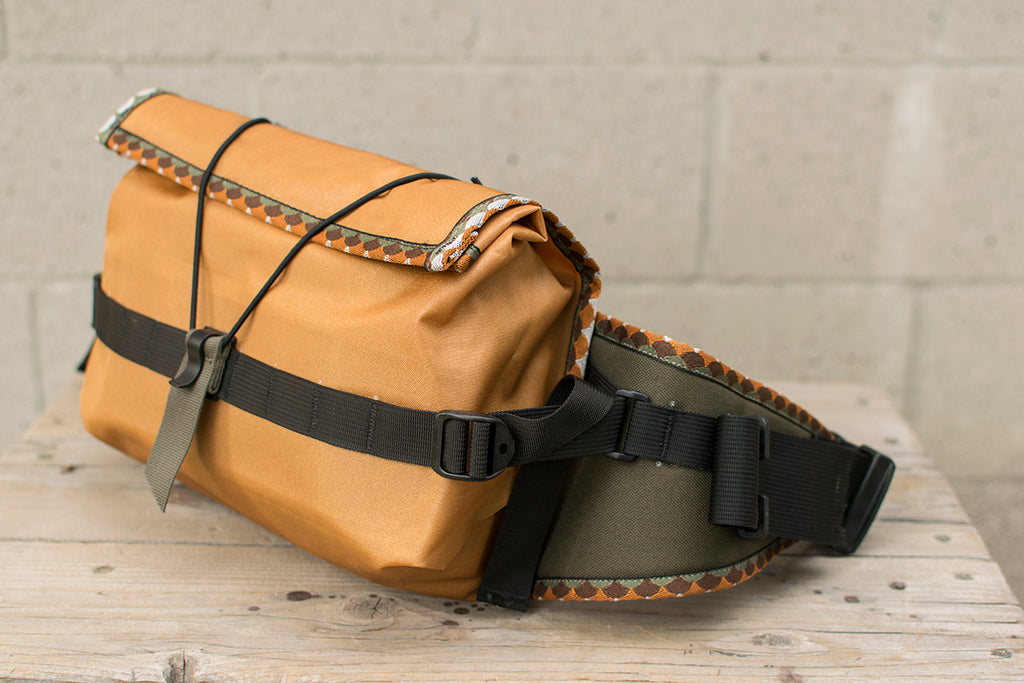 A side view of the orange Big Dumpling hip pack with Brown Trout patterned trim tape.