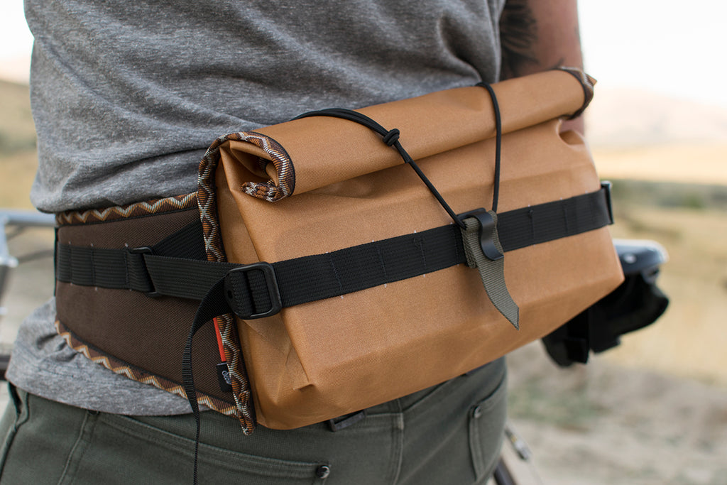 Person wearing an orange Big Dumpling hip pack with Western Rattler trim tape.