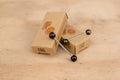Western brown and Eastern green Cable Cherries with cardboard packaging on wooden surface.
