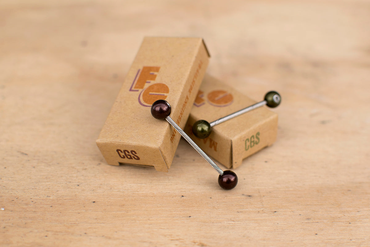 Western brown and Eastern green Cable Cherries with cardboard packaging on wooden surface.
