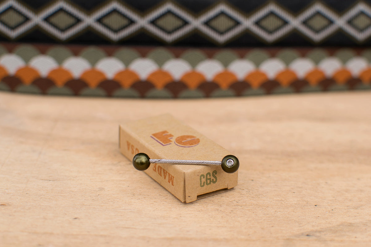 Eastern Green cable cherries on a wooden surface with Camp And Go Slow patterned bar tape in the background.