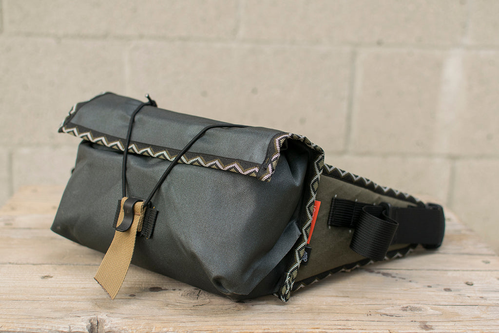 Side view of grey Little Dumpling hip pack with Eastern Rattler trim tape.