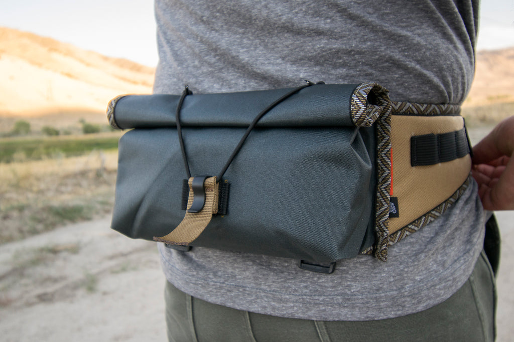 Person wearing a gray Little Dumpling hip pack with Great Horned trim tape.