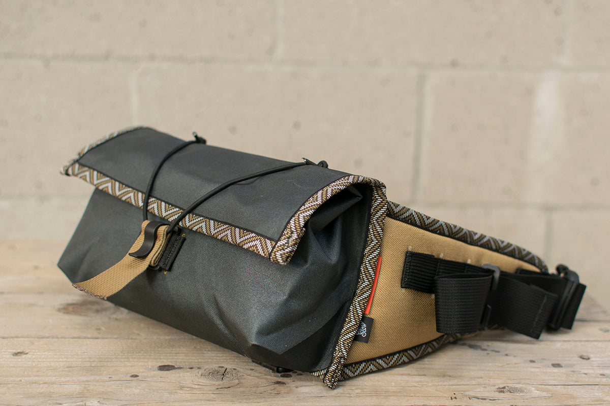 Side view of grey Little Dumpling hip pack with Great Horned Owl trim tape.