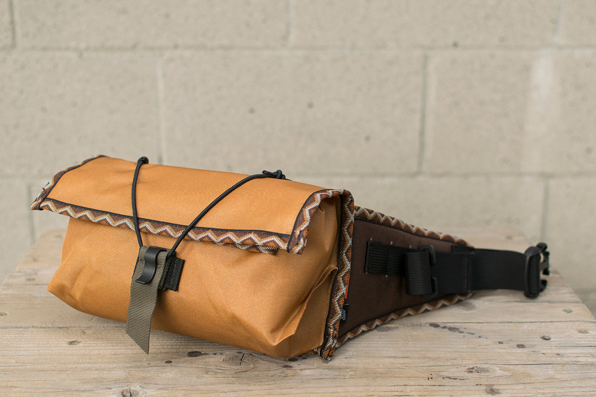 Side view of orange Little Dumpling hip pack with Western Rattler trim tape.